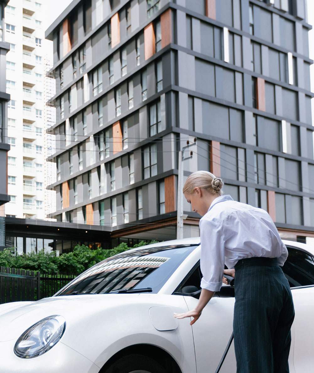 progressive-businesswoman-plugs-charger-plug-from-charging-station-ev