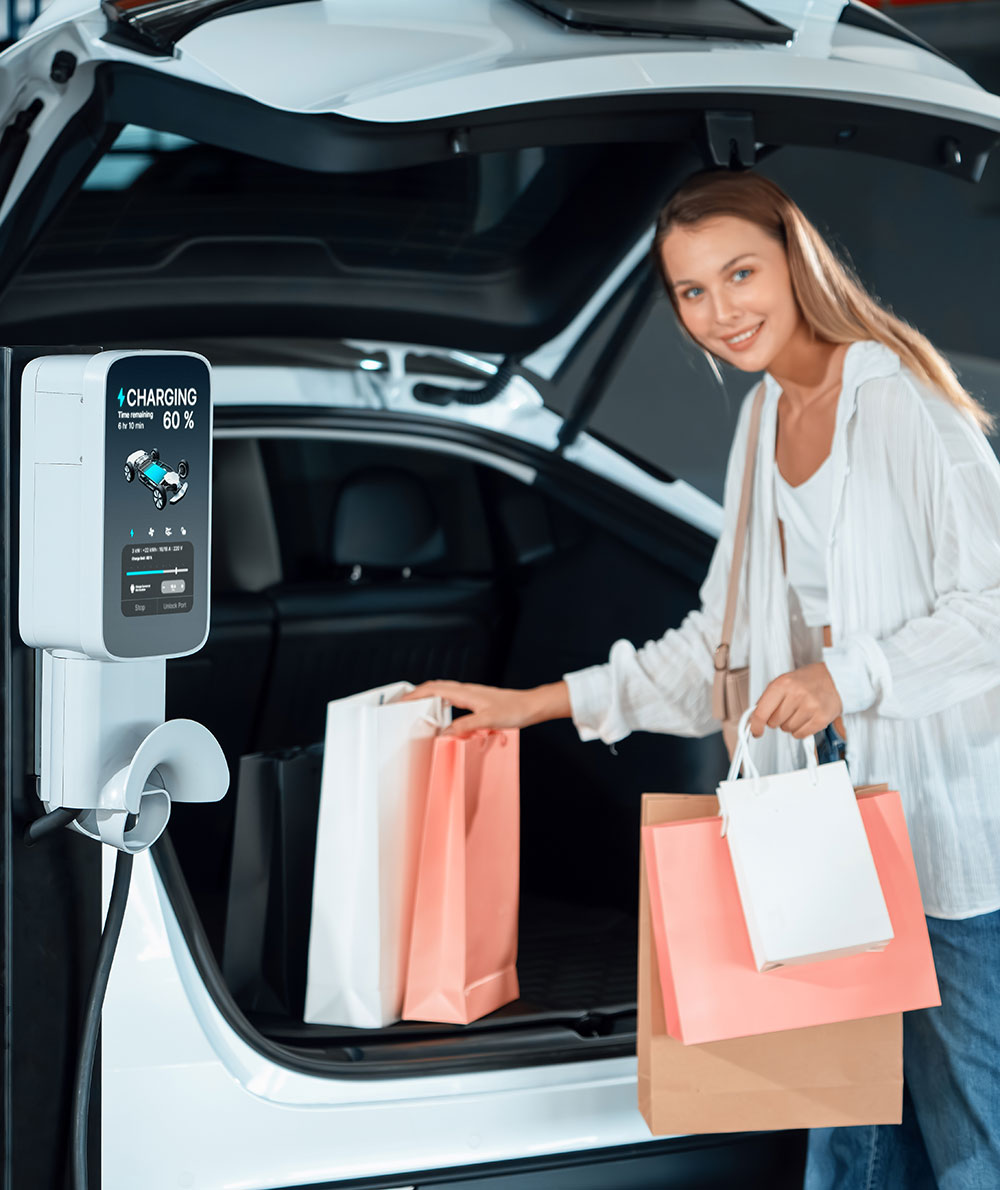 young-woman-travel-with-ev-electric-car-shopping-center-parking-lot-innards